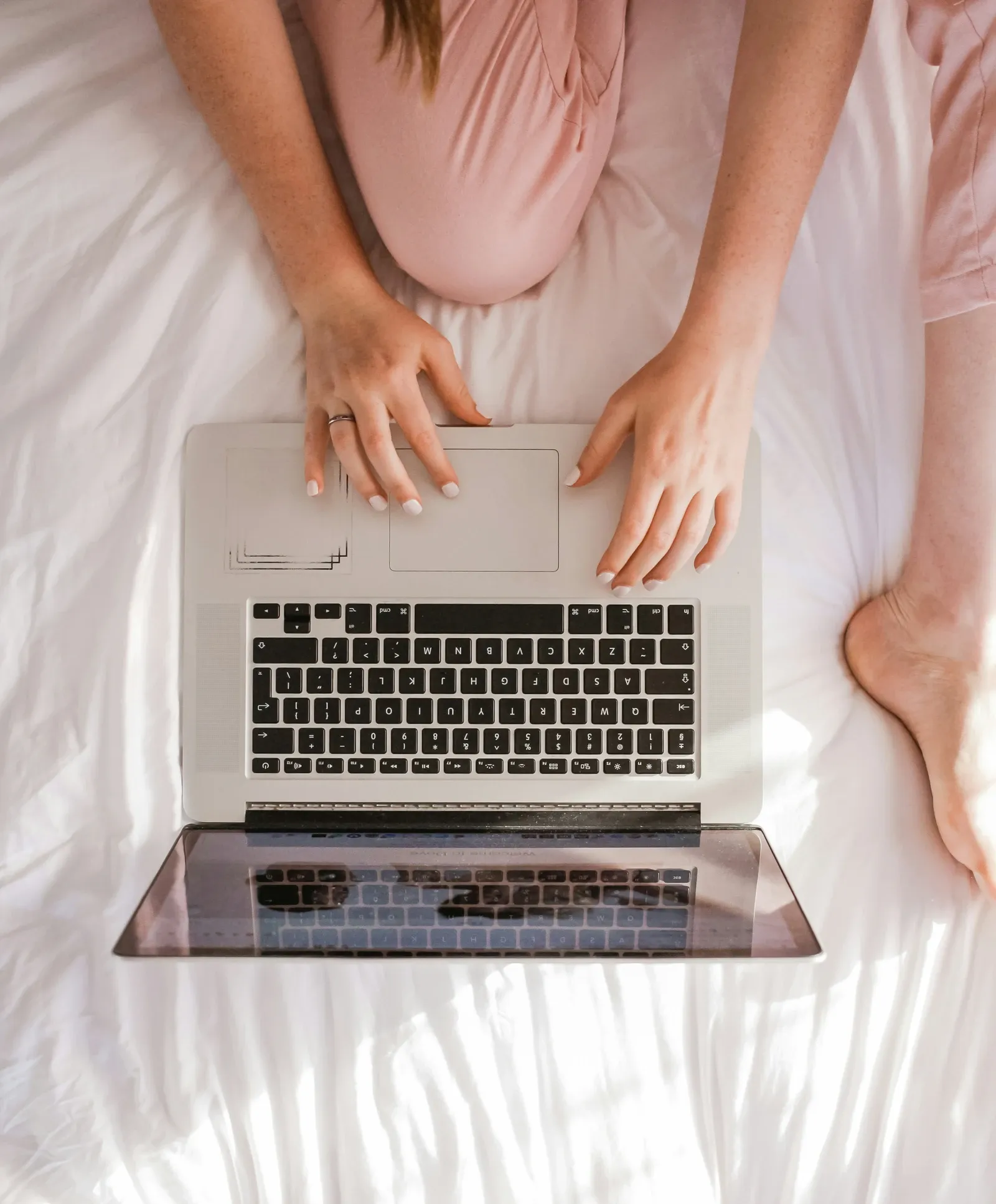 woman with laptop on bed